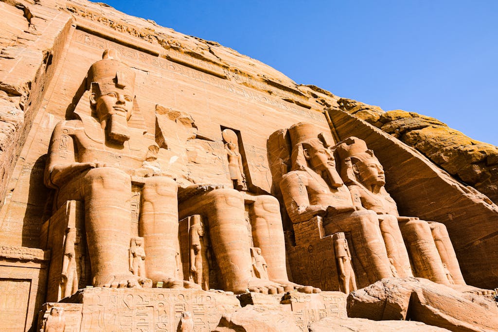 Discover the awe-inspiring ancient statues of Abu Simbel, Egypt with clear blue skies enhancing their grandeur.